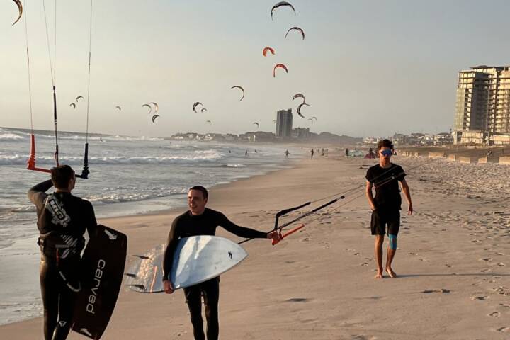 kiter geht am strand mit board unter dem arm