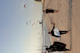 kiter geht am strand mit board unter dem arm