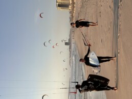 kiter geht am strand mit board unter dem arm